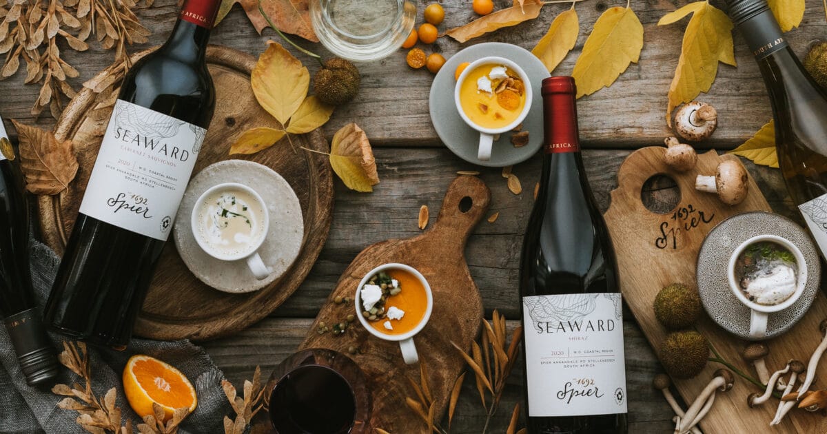 Winelands wine bottles and starter soups styled on a rustic wooden table
