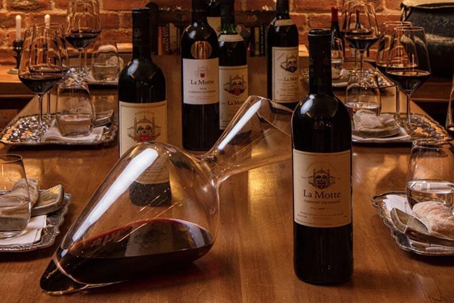 A cellar wine tasting table set with several bottles and a decanter